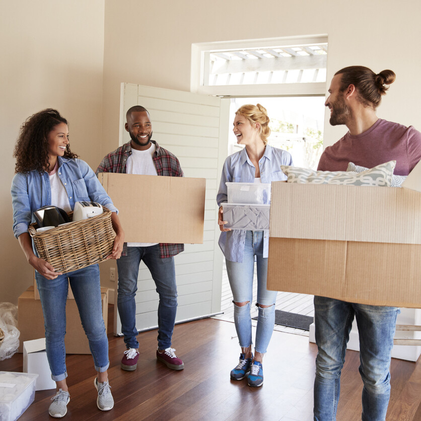 Des amis aident à déménager pour réduire le coût déménagement, en transportant des boîtes dans une nouvelle maison.