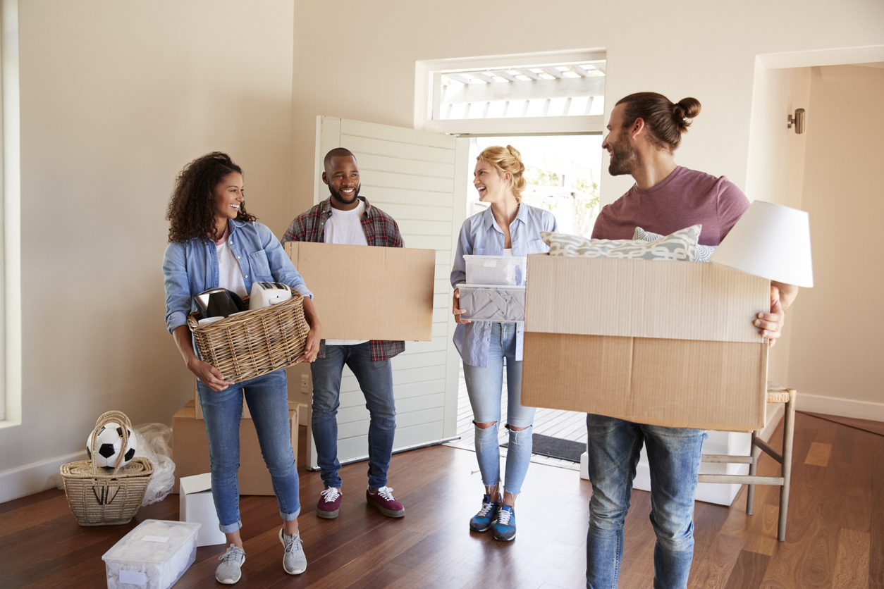 Des amis aident à déménager pour réduire le coût déménagement, en transportant des boîtes dans une nouvelle maison.