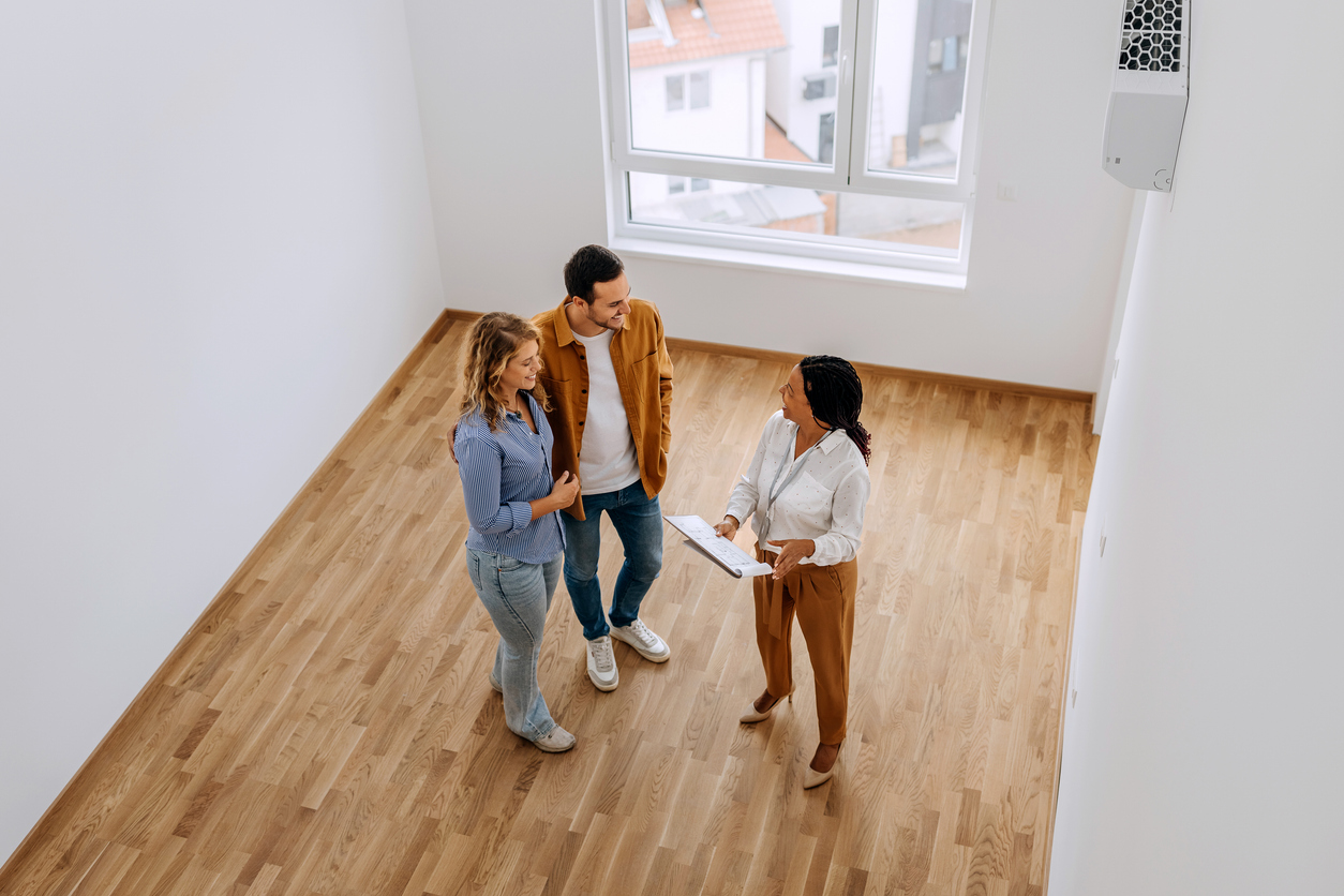 Un couple visite un appartement vide, illustrant le concept d’aide au loyer pour trouver un logement abordable au Québec.