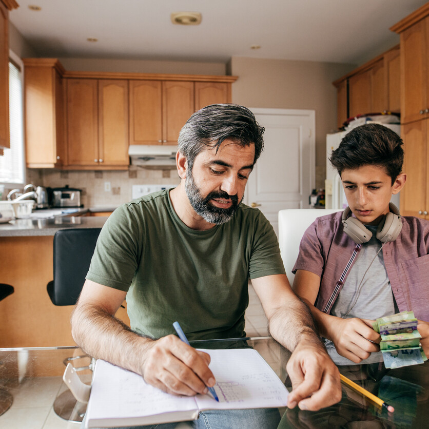 Ado et argent : un père enseigne à son adolescent à gérer son argent à la maison.