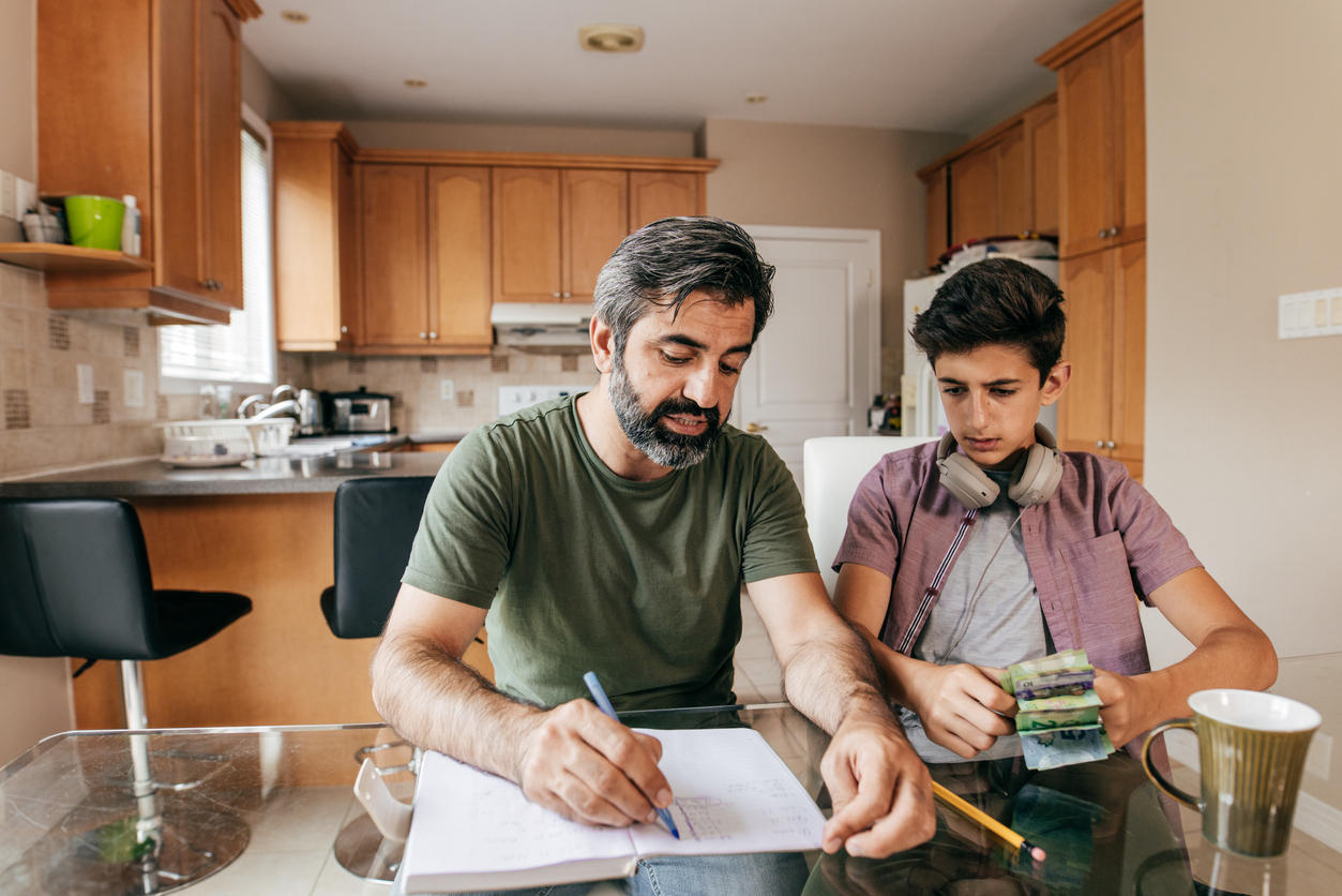 Ado et argent : un père enseigne à son adolescent à gérer son argent à la maison.