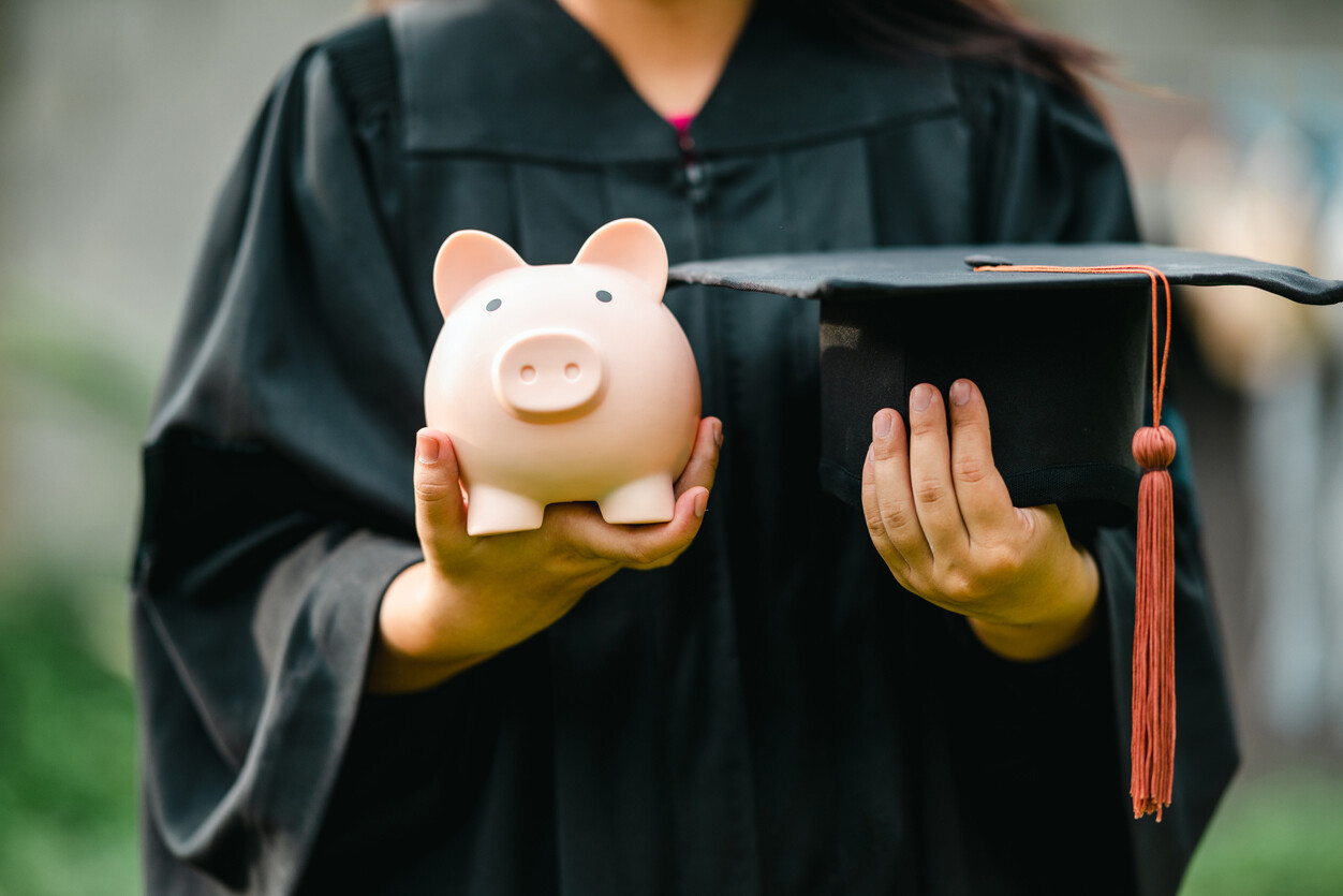 Image d’étudiant en toge avec tirelire et mortier, représentant les solutions pour financer les études postsecondaires efficacement.