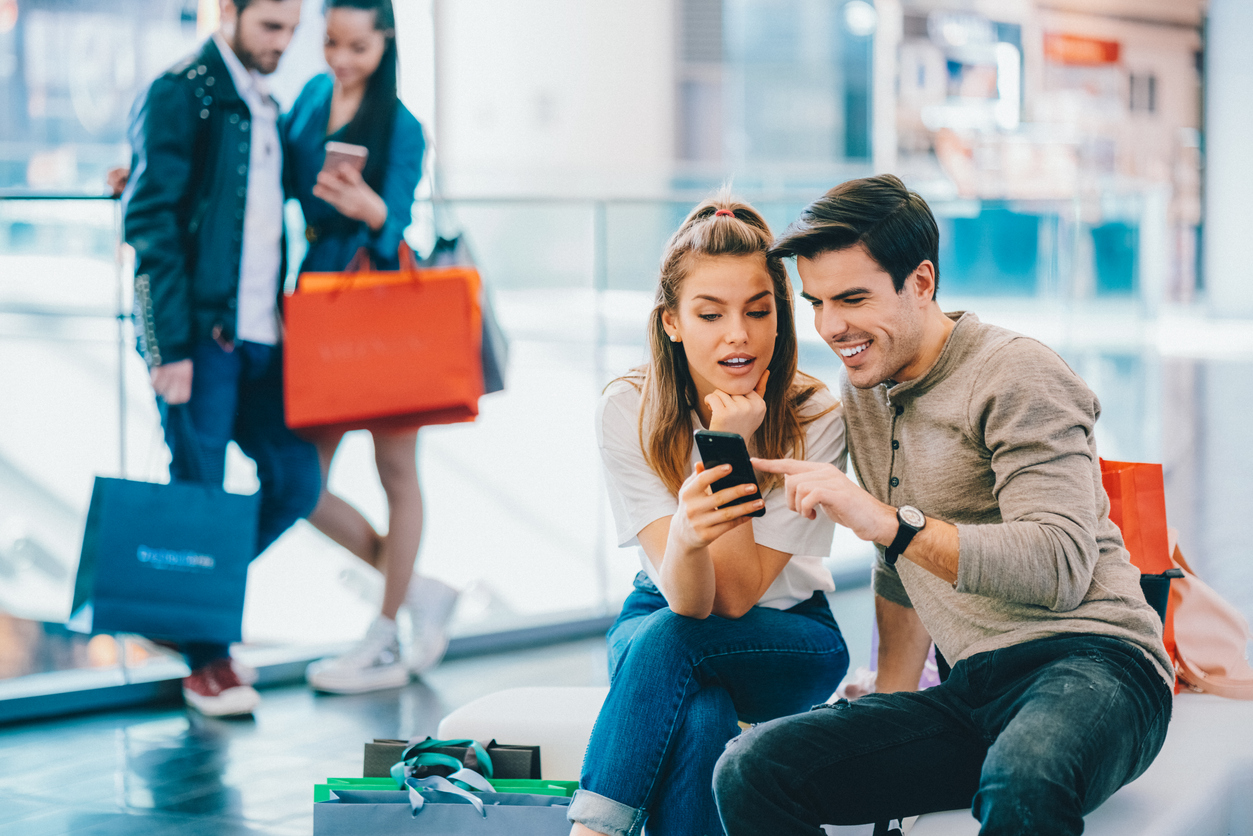 Jeunes adultes magasinant avec des amis et subissant la pression sociale qui influence leurs dépenses.