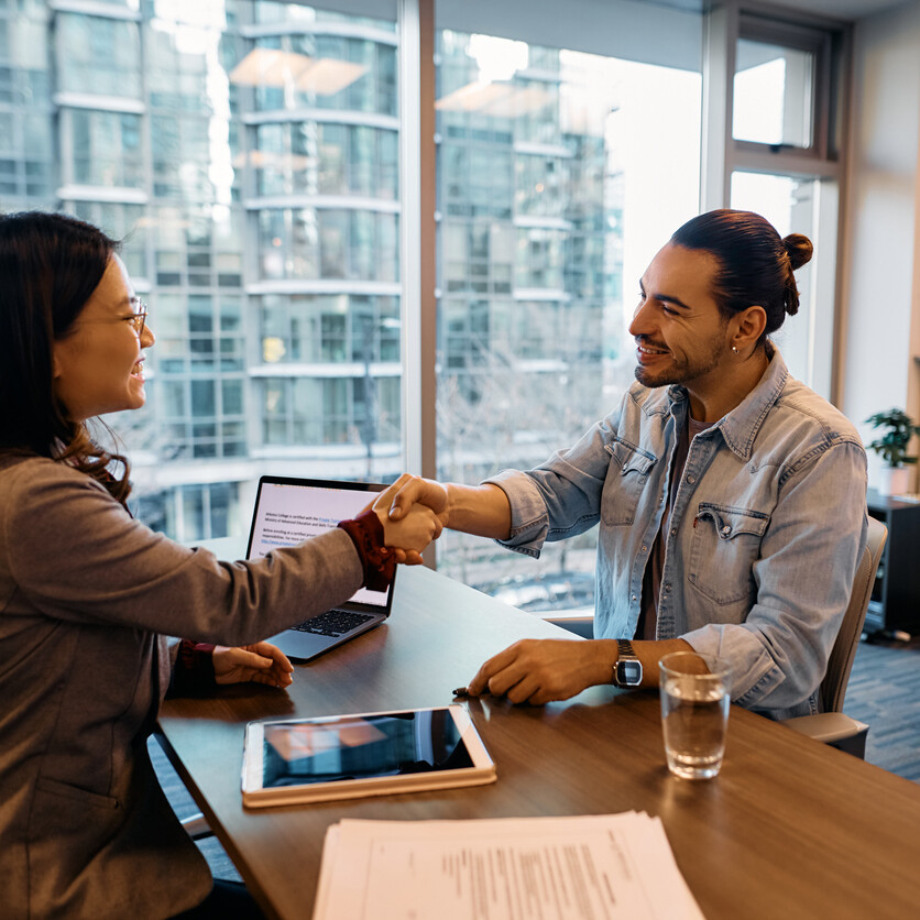 Professionnels se serrant la main après une entrevue réussie, illustrant un changement de carrière positif.